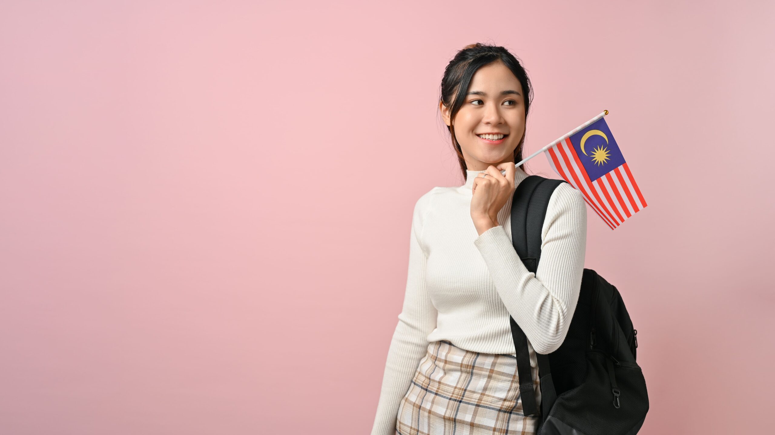 cheerful women showing malaysian flag and exploring opportunites to study in Malaysia from Nepal